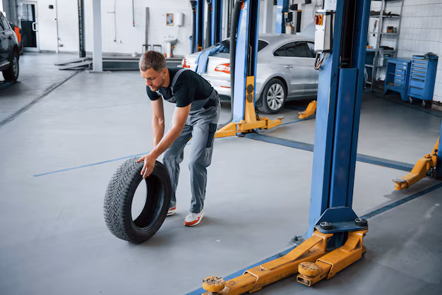 mechanic-holds-tire-repair-garage